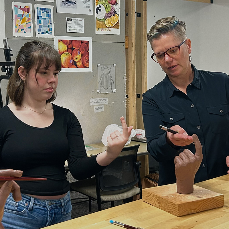 Kim Moss shows a detailed hand model to a student