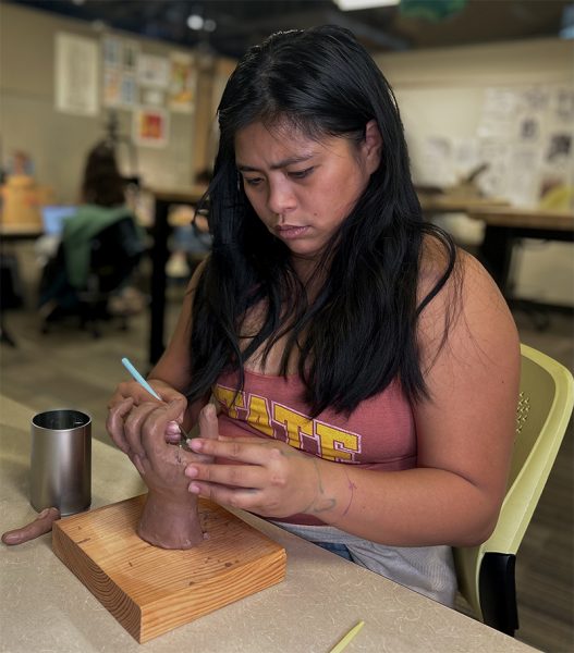 Student working on a hand sculpture